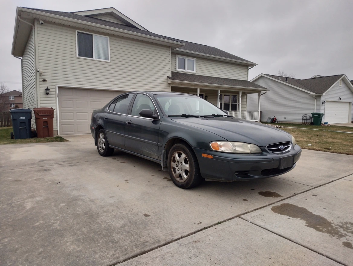 A car photographed on a plain forecourt in flat daylight